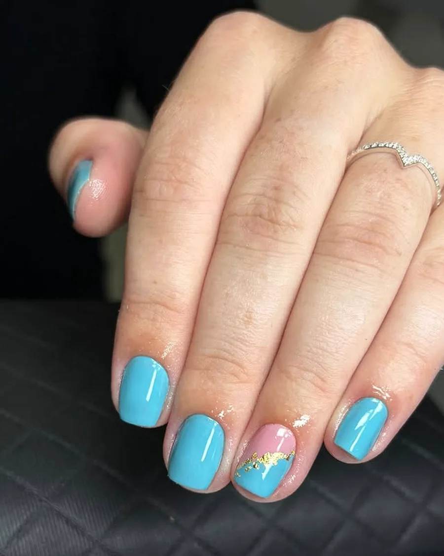 Unhas azuis com detalhes decorativos dourados