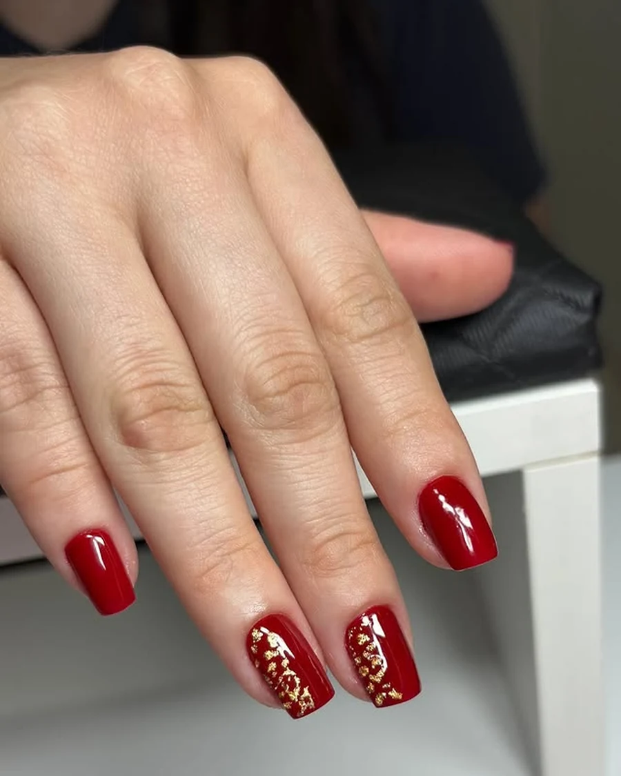 Unhas vermelhas com delicados detalhes dourados